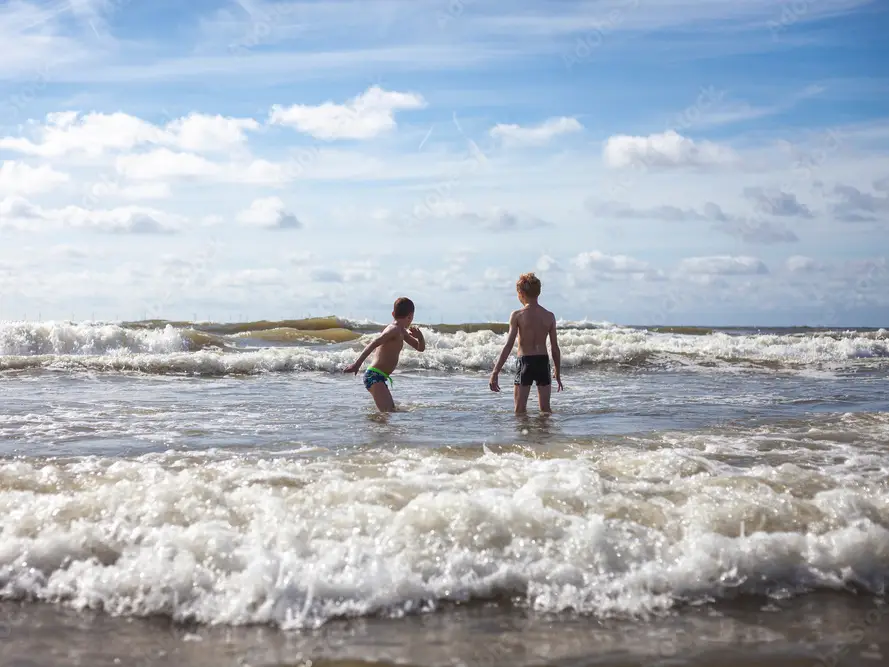 Zwei Kinder am Meer auf dem Weg Schwimmen zu gehen.